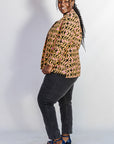 Model wearing beige, yellow and black geometric print shirt.