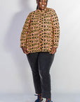 Model wearing beige, yellow and black geometric print shirt.