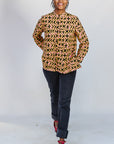 Model wearing beige, yellow and black geometric print shirt.
