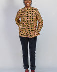 Model wearing beige, yellow and black geometric print shirt.
