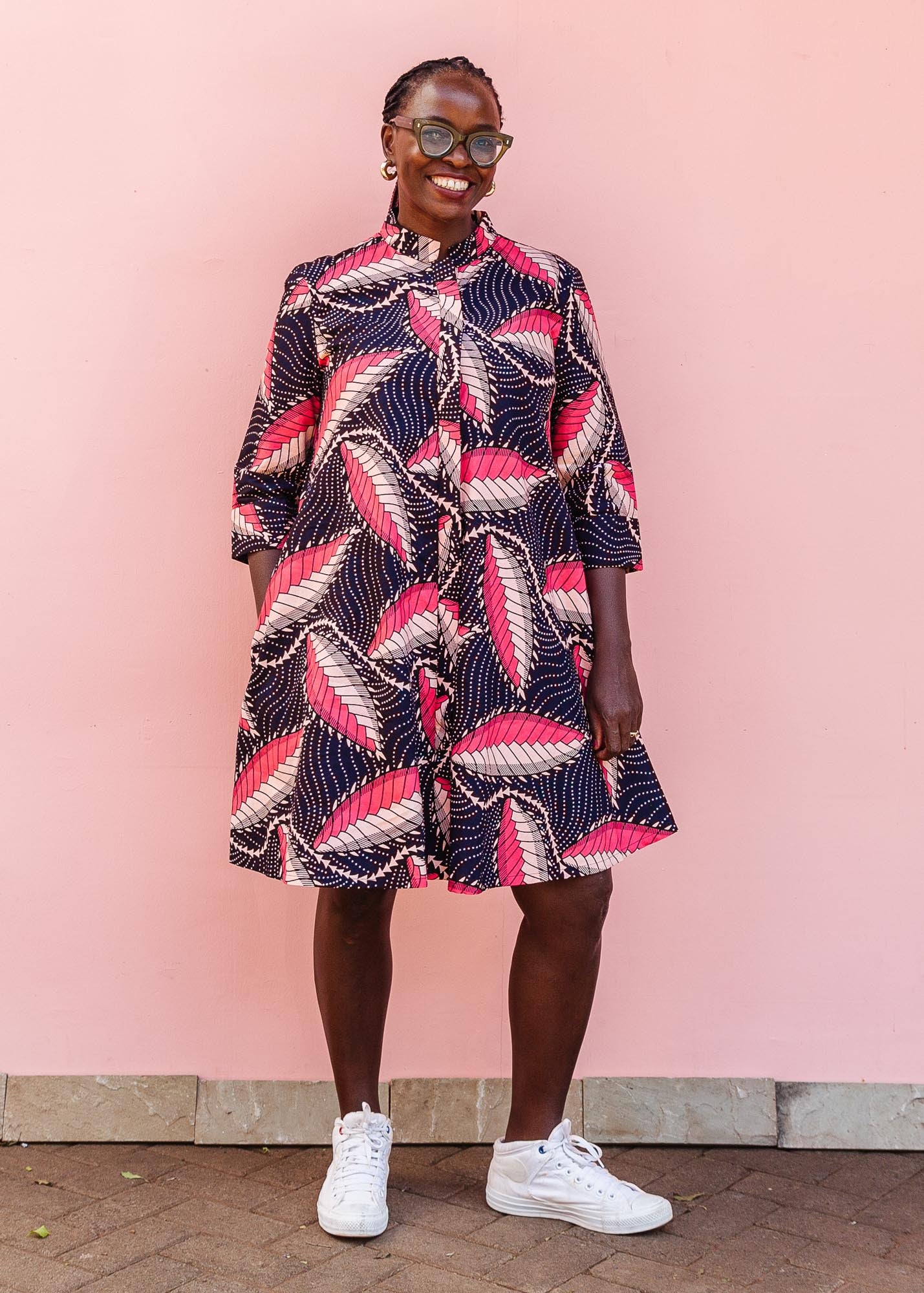 The model is wearing navy blue dress with black, pink and baby pink chrysalis