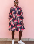 The model is wearing navy blue dress with black, pink and baby pink chrysalis