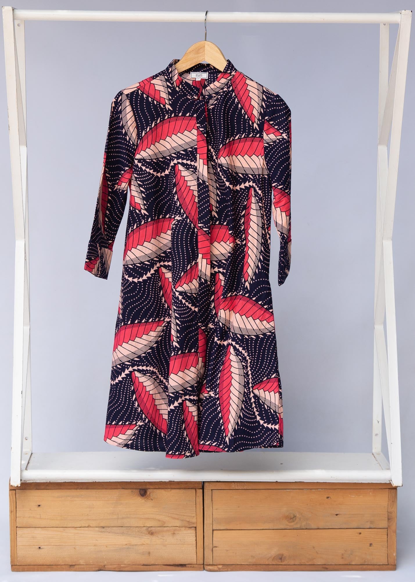 Display of navy blue dress with black, pink and baby pink chrysalis