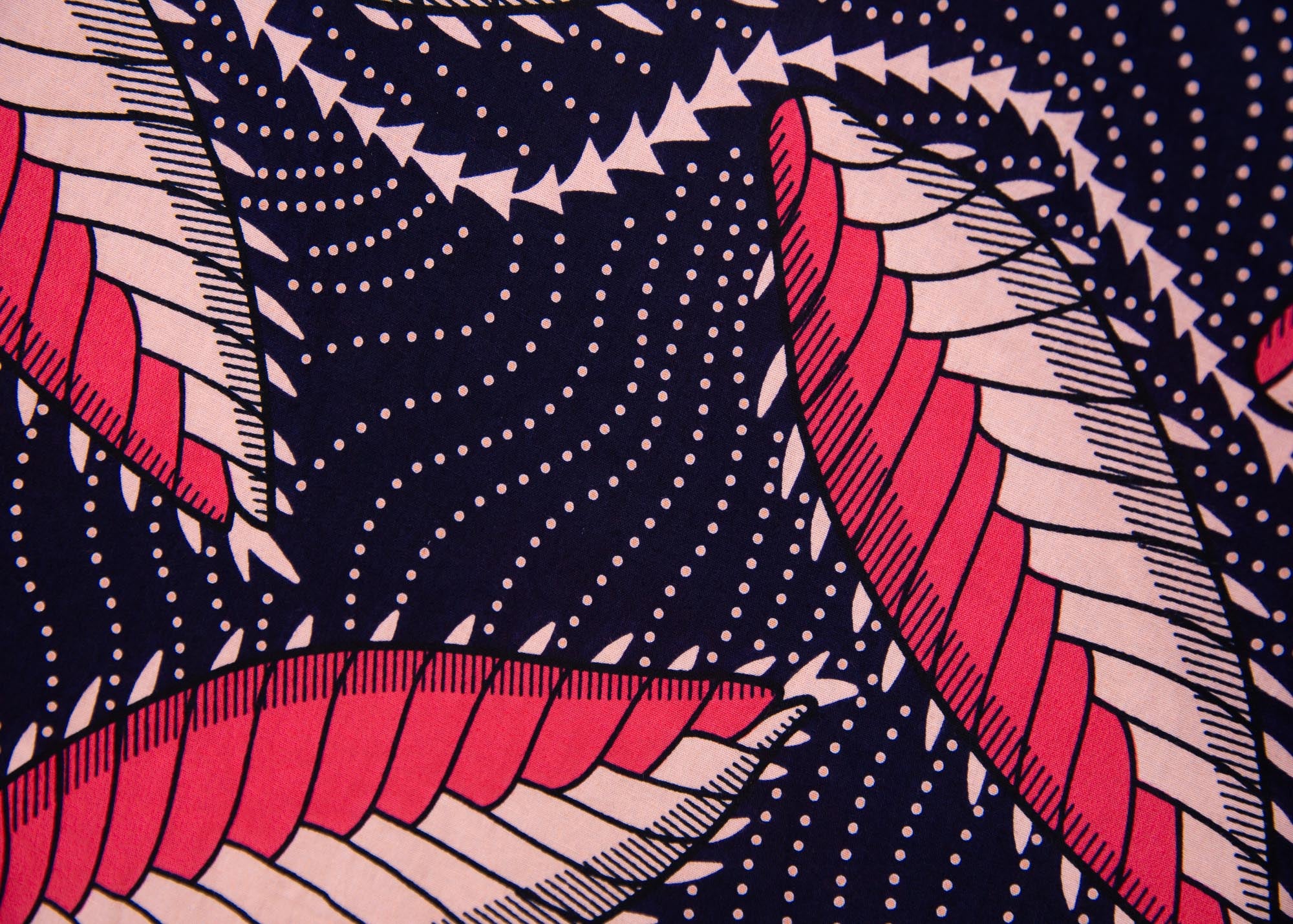 Close up display of navy blue dress with black, pink and baby pink chrysalis