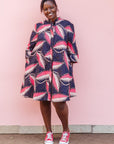 The model is wearing navy blue dress with black, pink and baby pink chrysalis