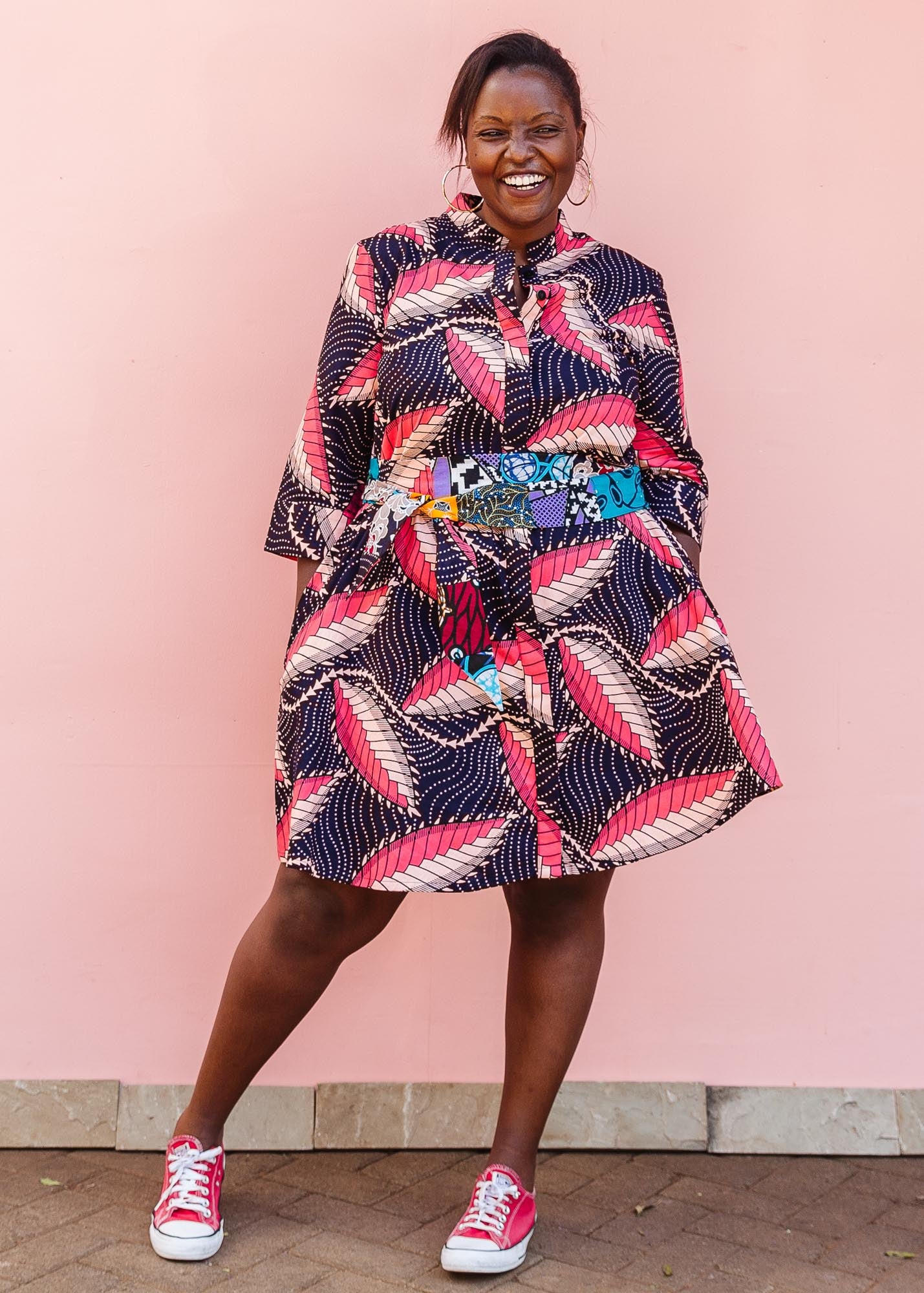 The model is wearing navy blue dress with black, pink and baby pink chrysalis
