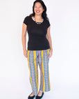 Model wearing yellow pants with blue zig zag pattern.