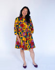 Model wearing yellow dress with multicolor floral print.