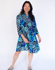 Model wearing dress with blue and grey gear graphic print.