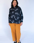 Model wearing black long sleeved shirt with white music print design.