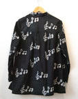 Display of black long sleeved shirt with white music print design.