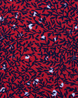 Close up display of red dress with black and white vine print, fabric.