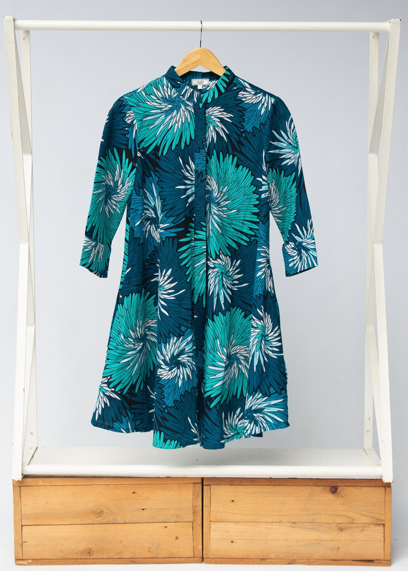 Display of turquoise, black, pacific blue, slate and white feathered spiral print dress