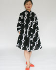 Model wearing black and white geometric print dress.