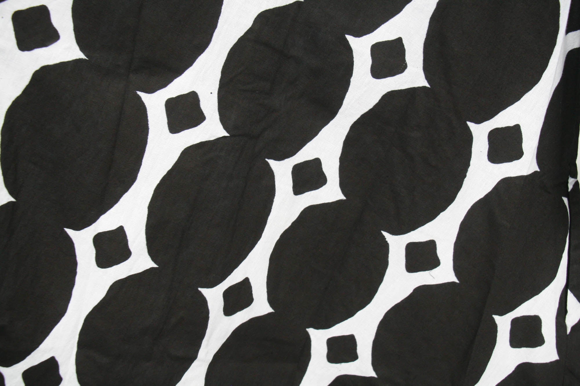 Close up display of black and white geometric print dress.