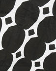 Close up display of black and white geometric print dress.