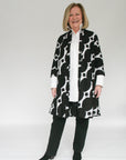 Model wearing black and white geometric print dress.