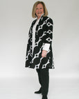 Model wearing black and white geometric print dress.