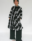 Model wearing black and white geometric print dress.