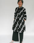 Model wearing black and white geometric print dress.