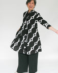 Model wearing black and white geometric print dress.