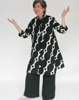 Model wearing black and white geometric print dress.