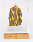 Display of yellow, brown and white abstract print shirt.