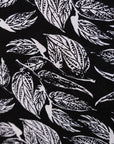 Close up display of black and white leaf print dress, fabric.