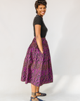 Model wearing fuchsia skirt with small dot design.