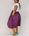 Model wearing fuchsia skirt with small dot design.