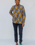 Model wearing of blue, white and yellow abstract print shirt.