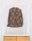 Display of blue, white and yellow abstract print shirt.