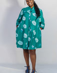 Model wearing teal dress with white cat print.