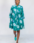 Model wearing teal dress with white cat print.