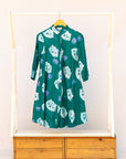 Display of teal dress with white cat print.