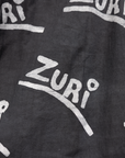 Close up display of black and white long sleeve shirt with Zuri graphic print, fabric.