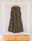 Display of black sleeveless dress with rainbow circle print.
