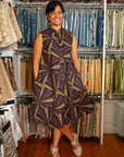 The model is wearing multi-colored abstract print dress