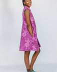 Model wearing purple dress with pink beet print.