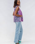Model wearing purple, pink and white geometric print, patchwork sleeveless shirt.