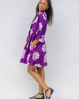 Model wearing purple and white floral print dress.