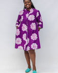 Model wearing purple and white floral print dress.