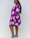 Model wearing purple and white floral print dress.