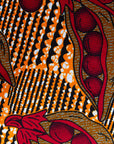 Close up display of brown dress with red snap pea print, fabric.