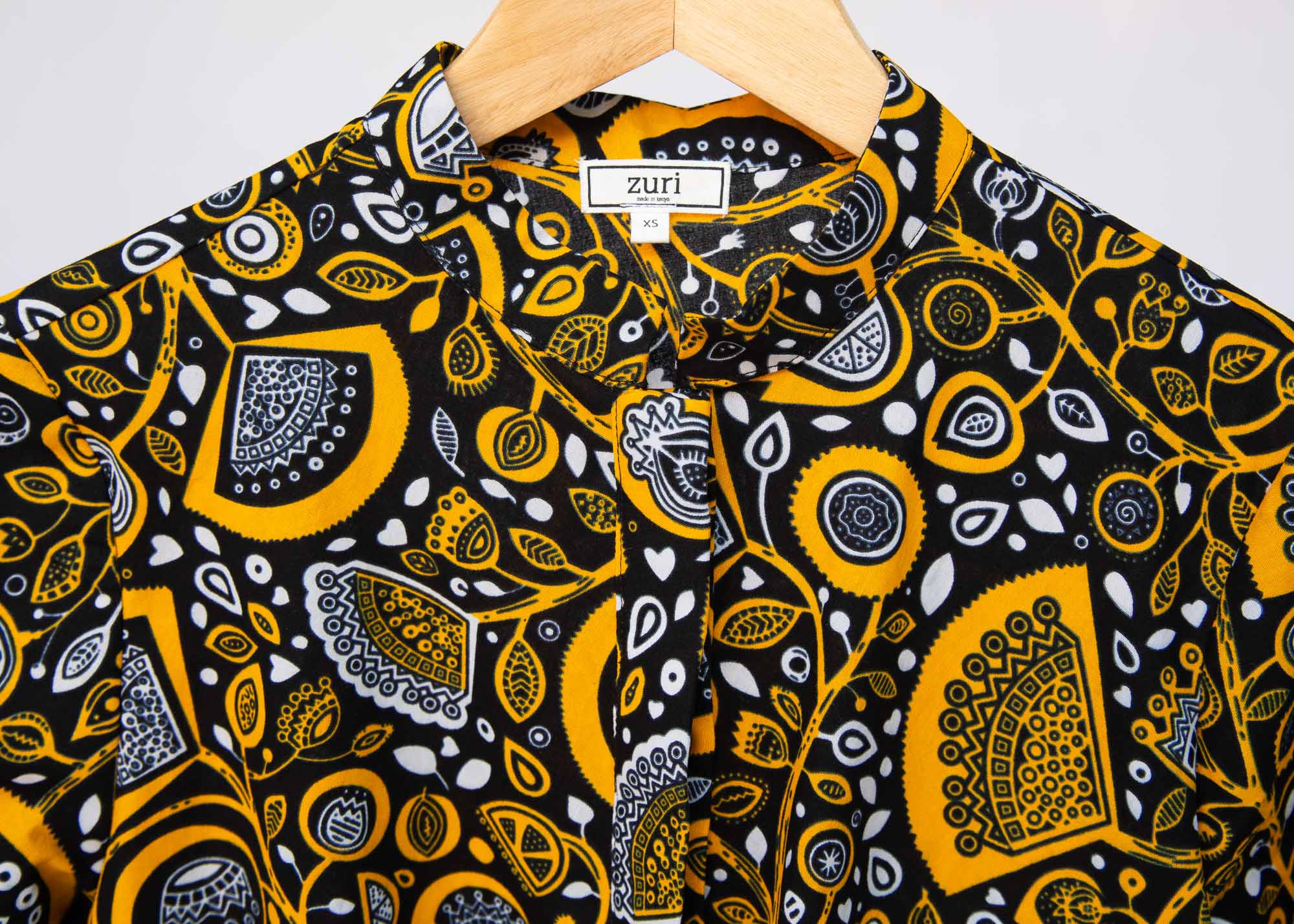 Display of black dress with white and yellow botanical print