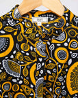 Display of black dress with white and yellow botanical print