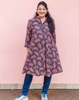 The model is wearing coral, pink, white and navy blue colored dress