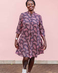 The model is wearing coral, pink, white and navy blue colored dress