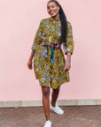 The model is wearing black dress with white and yellow botanical print paired with patchwork belt