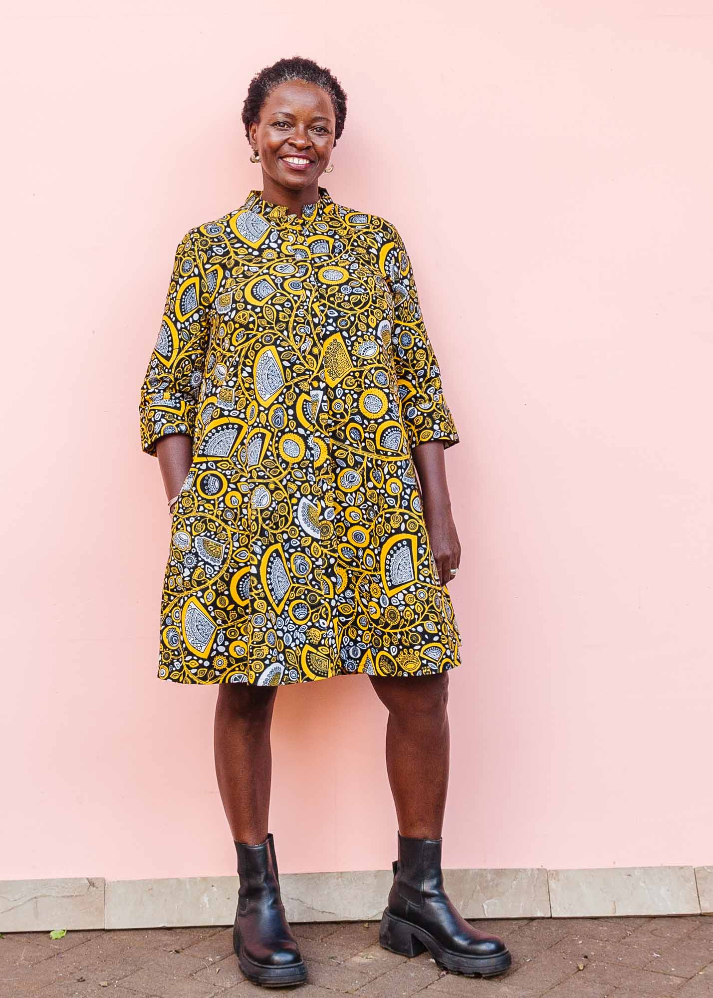 The model is wearing black dress with white and yellow botanical print
